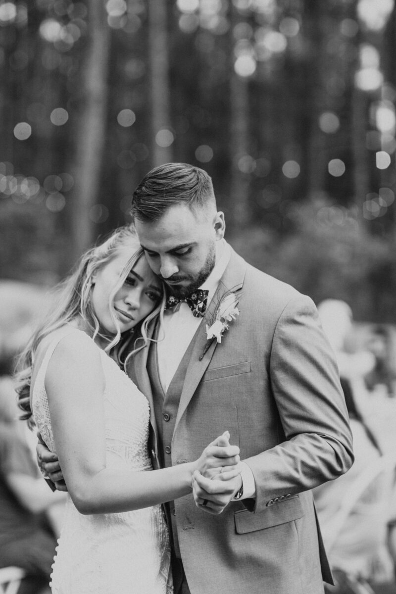 groom seeing bride in her wedding dress for the first time while standing in large open field