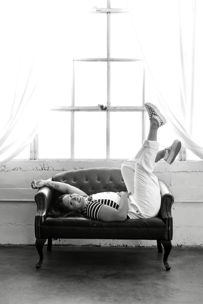 joyce laying on a couch with feet thrown up in the air