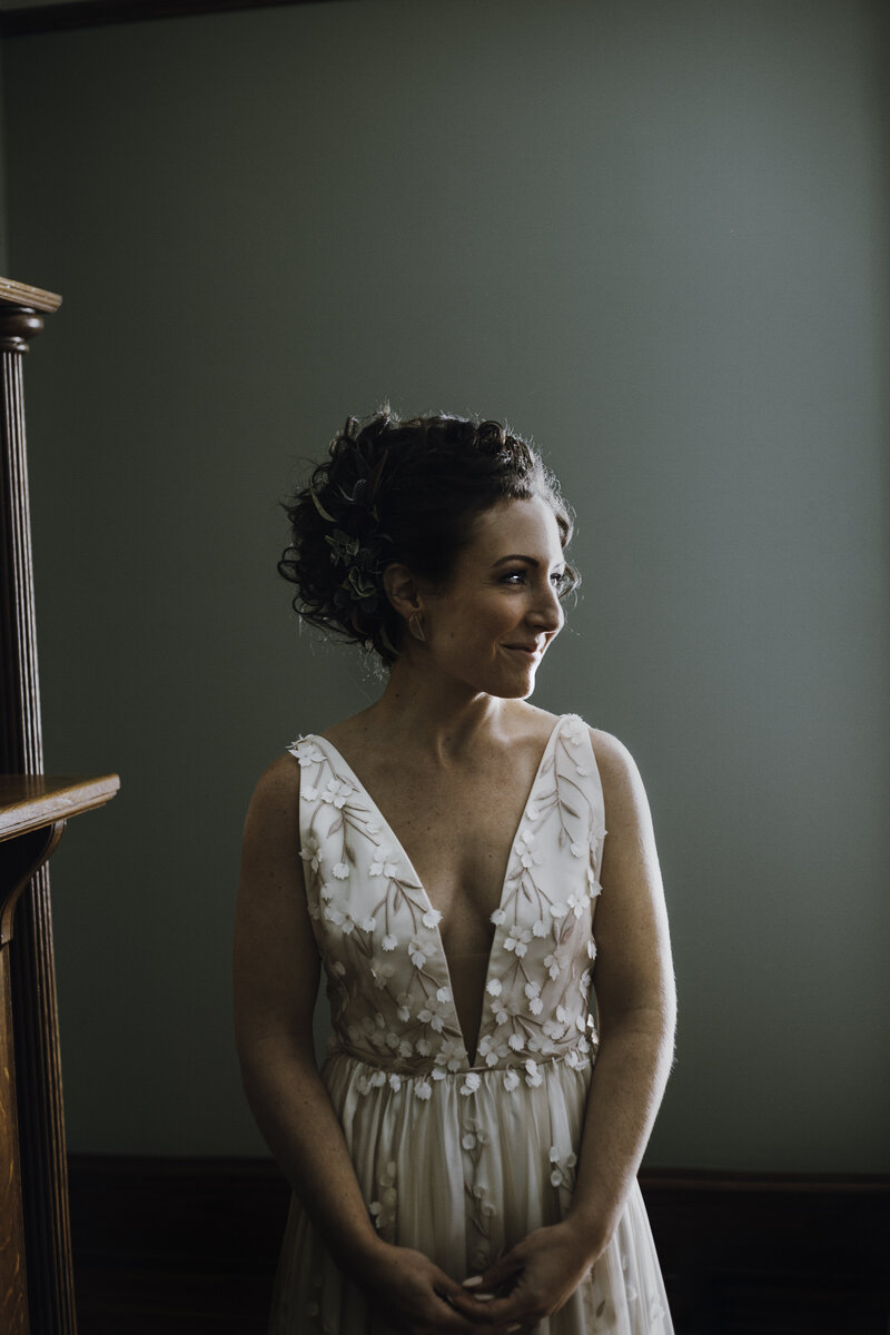 bride in white dress standing in green room