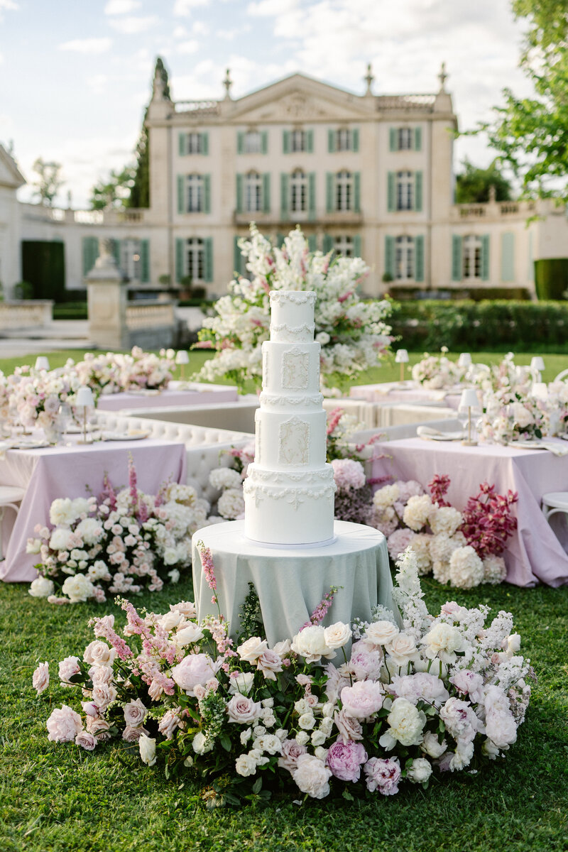 Pièce montée et tables du dîner fleuries devant le Château de Tourreau, photographiées par Marion Pinel