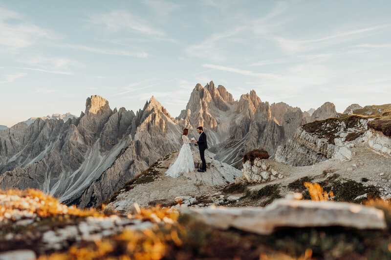 couple holding hands in wedding attire in Washington mountains