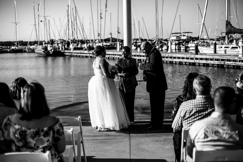 Wedding ceremony in front of the flagpole at the Erie Yacht Club