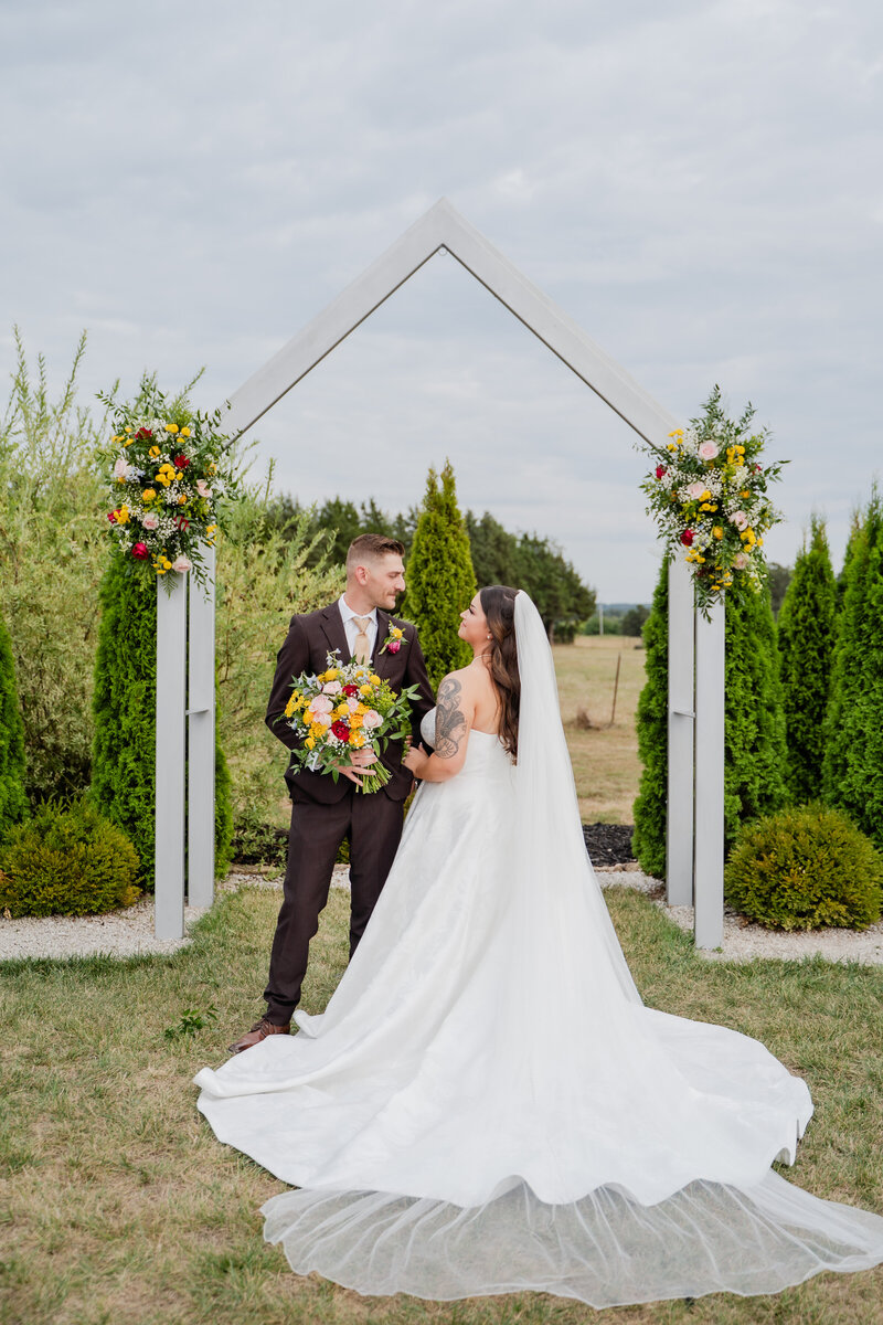 Bride and groom dip kissing halfway down the isle with their family and friends smiling on them