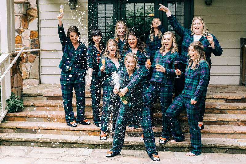 bridal party sprays champagne in matching pajamas by winx photo tennessee wedding photographer