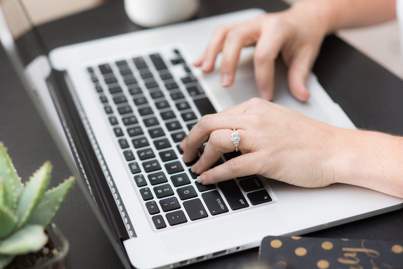 female wedding photographer typing on laptop