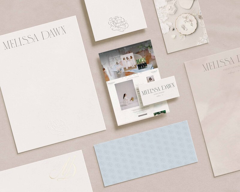 A flat lay presentation displays the expert craftmanship of Bayou Brand House, a Showit designer and branding designer, showing various stationary and webpage mockups for Melissa Dawn Event Designs.