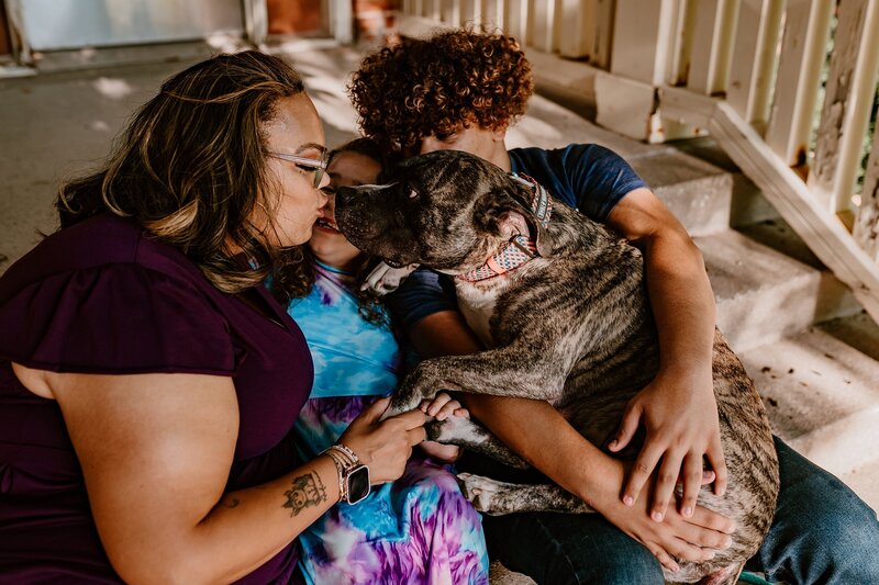 Family-Cuddles-With-Dog-on-Porch-Iowa-State-University-Ames-iowa-Storyteller-Collective-Photo-Co