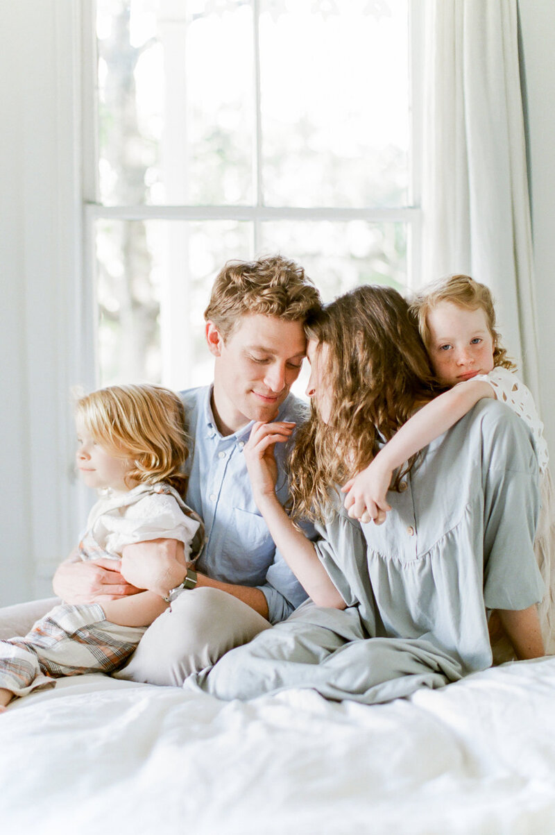 family snuggles on bed by Orlando lifestyle photographer