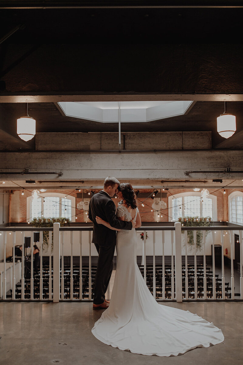 Bride and groom holding each other and about to kiss at The Evergreen Event Space