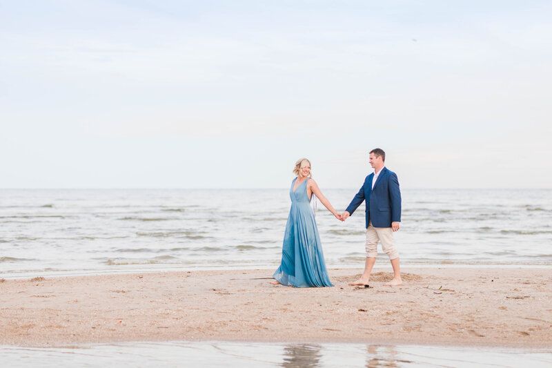Tara and her husband on the beach holding hands