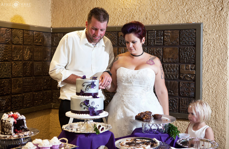 Bride and groom cut cake inside the City Park Pavilion Wedding Reception in Denver