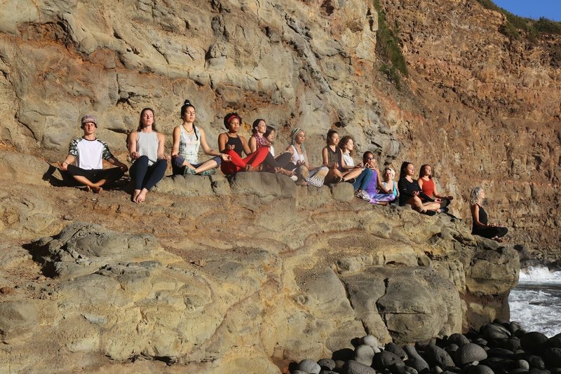Row of YTT graduates meditating on the beach in Kapaau Hawaii