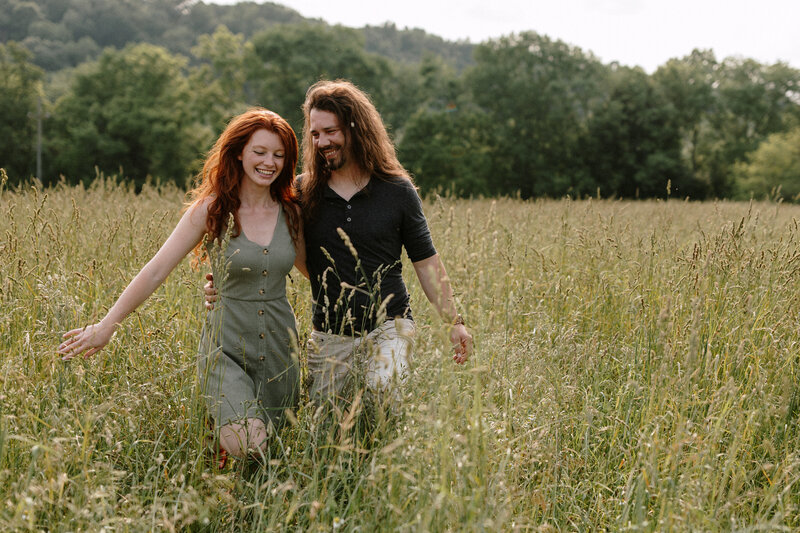 A happy couple, enjoying a sunny day together in a beautiful field, surrounded by nature's beauty.