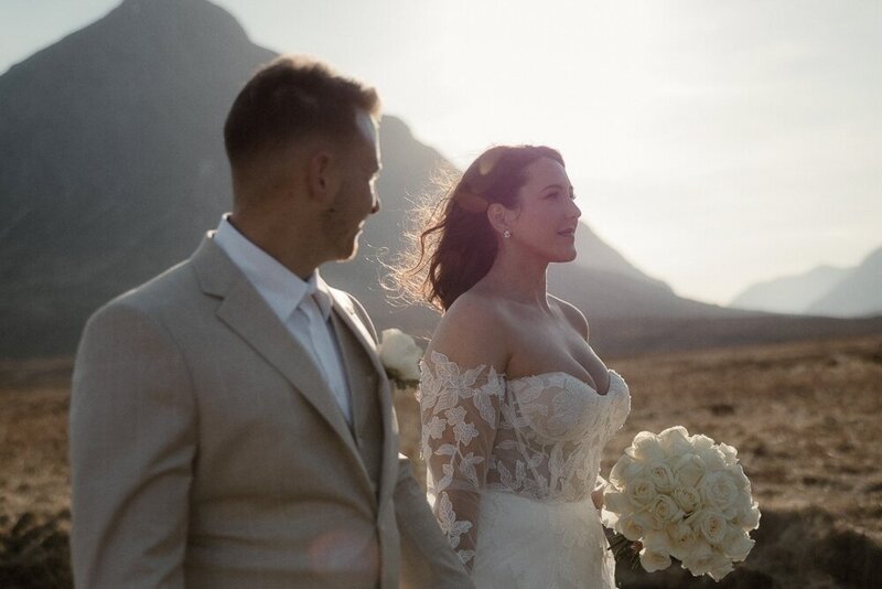 Couple hold hands and admire the scenery after their elopement  in Loch Lomond, Scotland