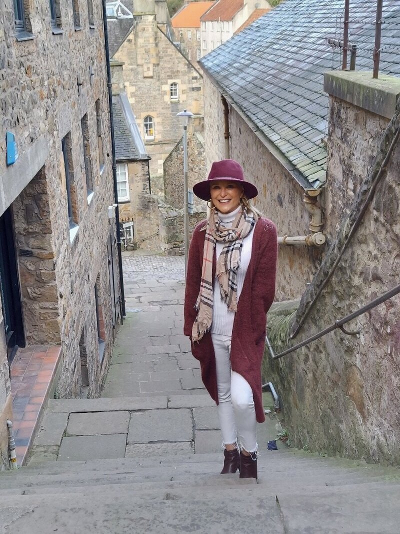 Traveler standing on steps of stone staircase in Old Town Edinburgh