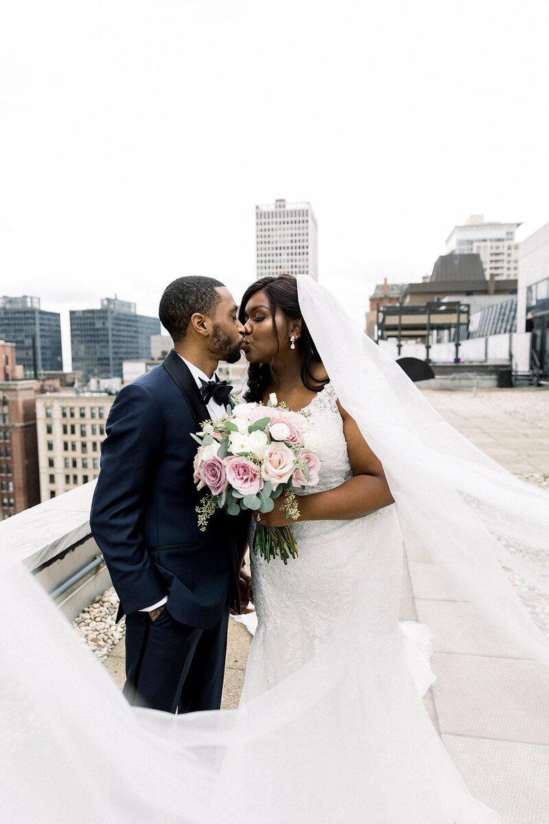 bride and groom kissing on chicago rooftop