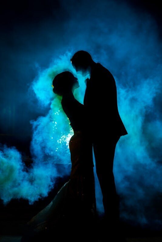 blue smoke bombs add an intense backdrop to bride and grooms portrait session
