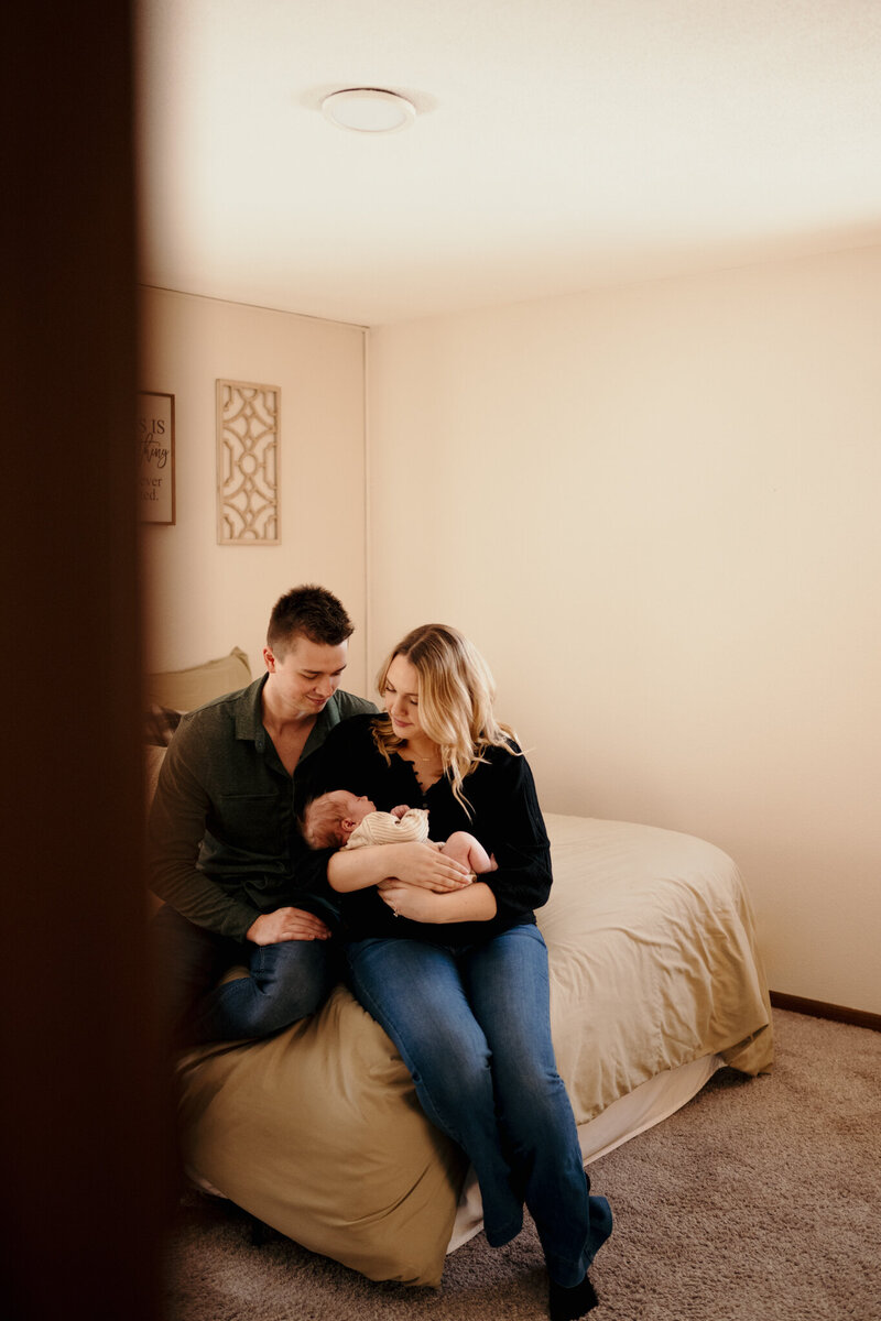 couple sitting in their home with newborn