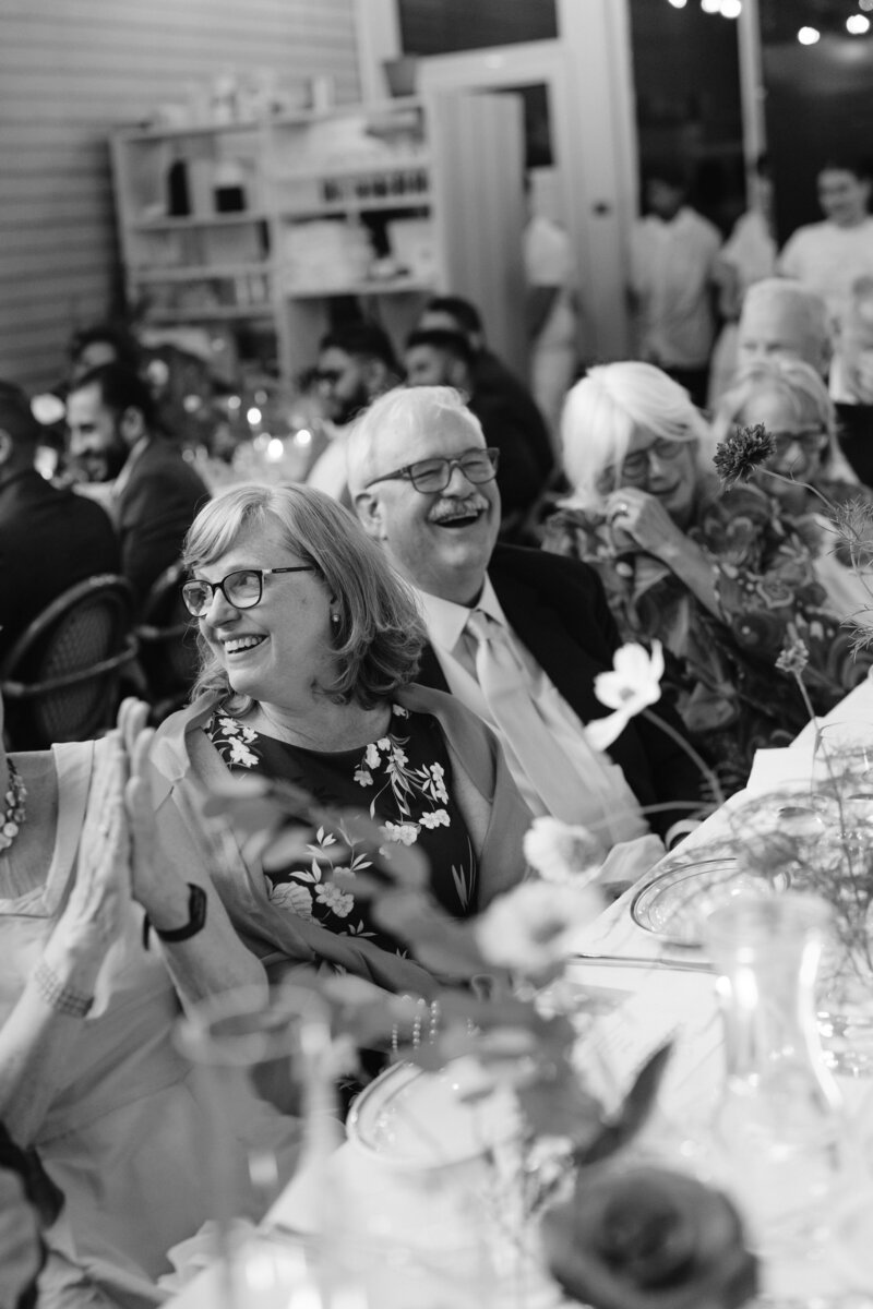 people sitting at a long table laughing 
