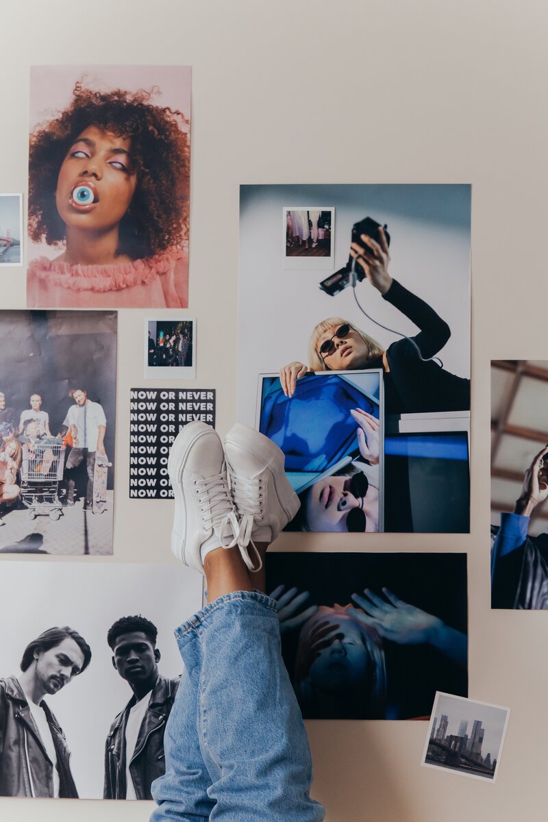 Photo is of a wall of posters with feet poking up