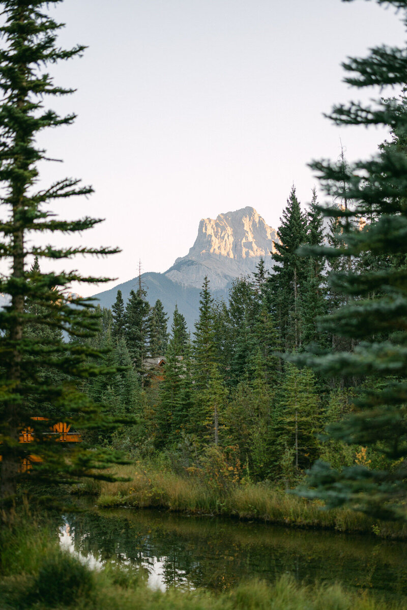 This stunning photograph captures the Three Sisters mountain range in Canmore during the evening reception at the Malcolm Hotel, taken at sunset on the couple's wedding day. The breathtaking view enhances the beauty and joy of the celebration, creating a memorable moment.
