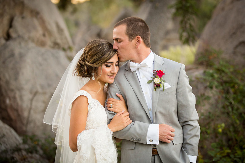 groom kissing brides head