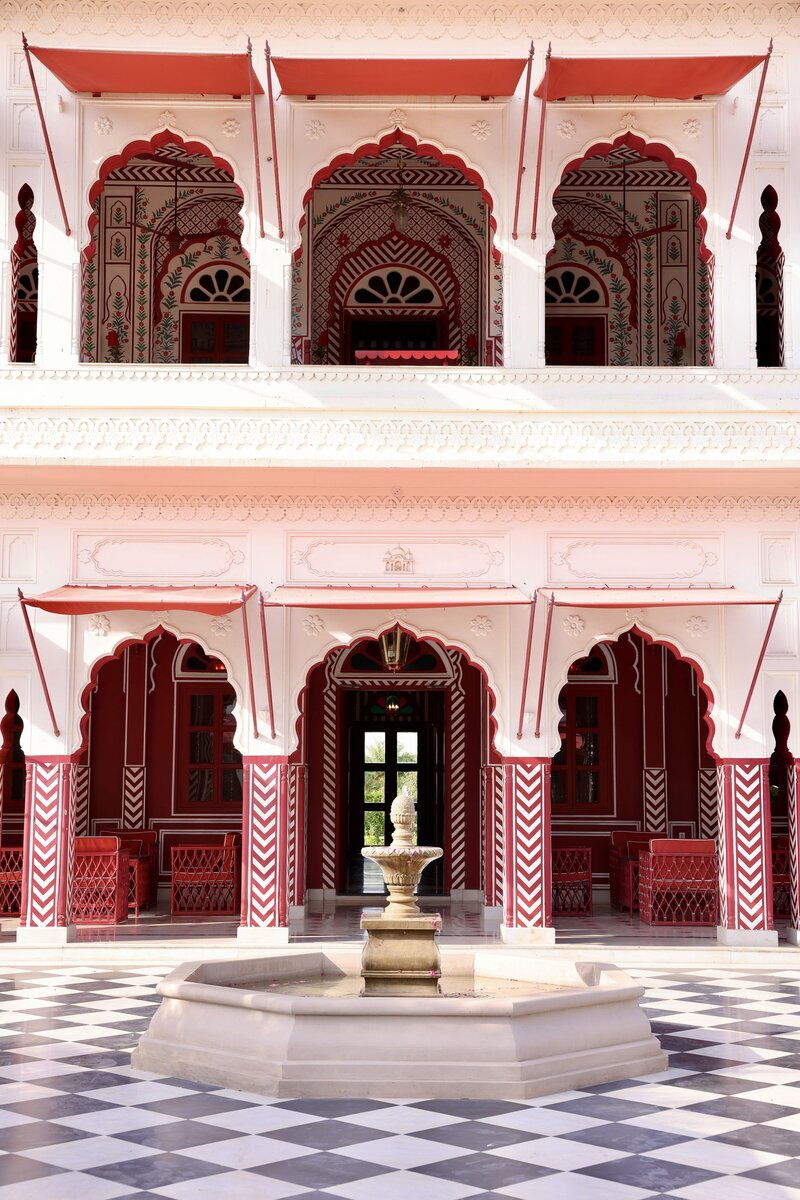 Ornate Indian palace courtyard with arches and a fountain, symbolising cultural heritage in bespoke travel.