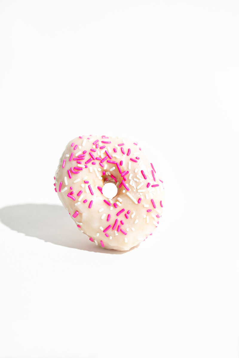 Pink and White Sprinkle Donut on a White Background - Daylight Donuts
