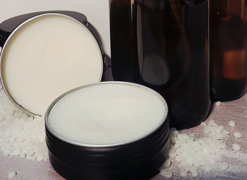 Display of Berry and Balm magnesium arnica body balm in a tin surrounded by amber bottles