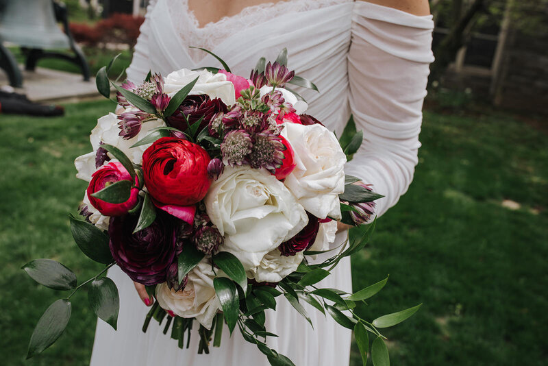 A close up of a person holding a bouquet of flowers