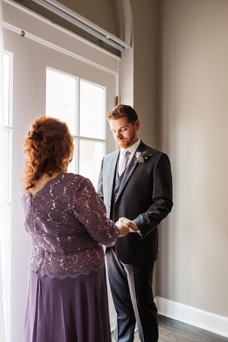 Groom and his mother getting ready on a wedding day. Intimate wedding photography with family by Claire Katan.