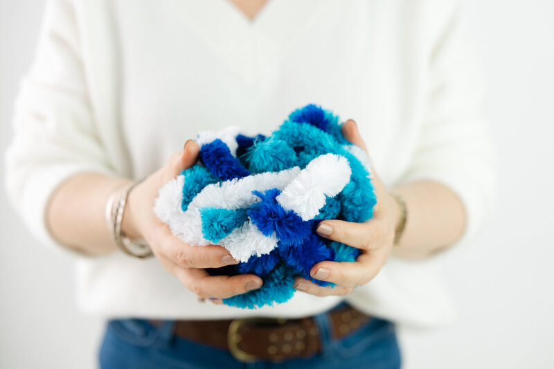Hands holding blue and white stress toy symbolizing calm and nervous system balance