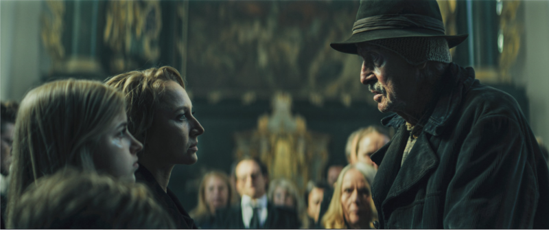 A mysterious interior scene lit with warm tones, emphasizing emotional tension.