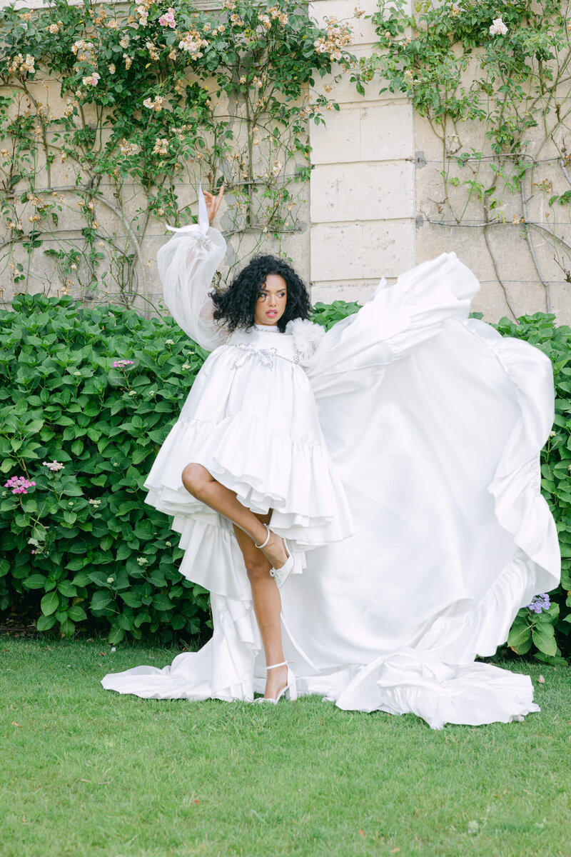 Bride posing for a photo in the gardens of chateau du grand luce during her wedding