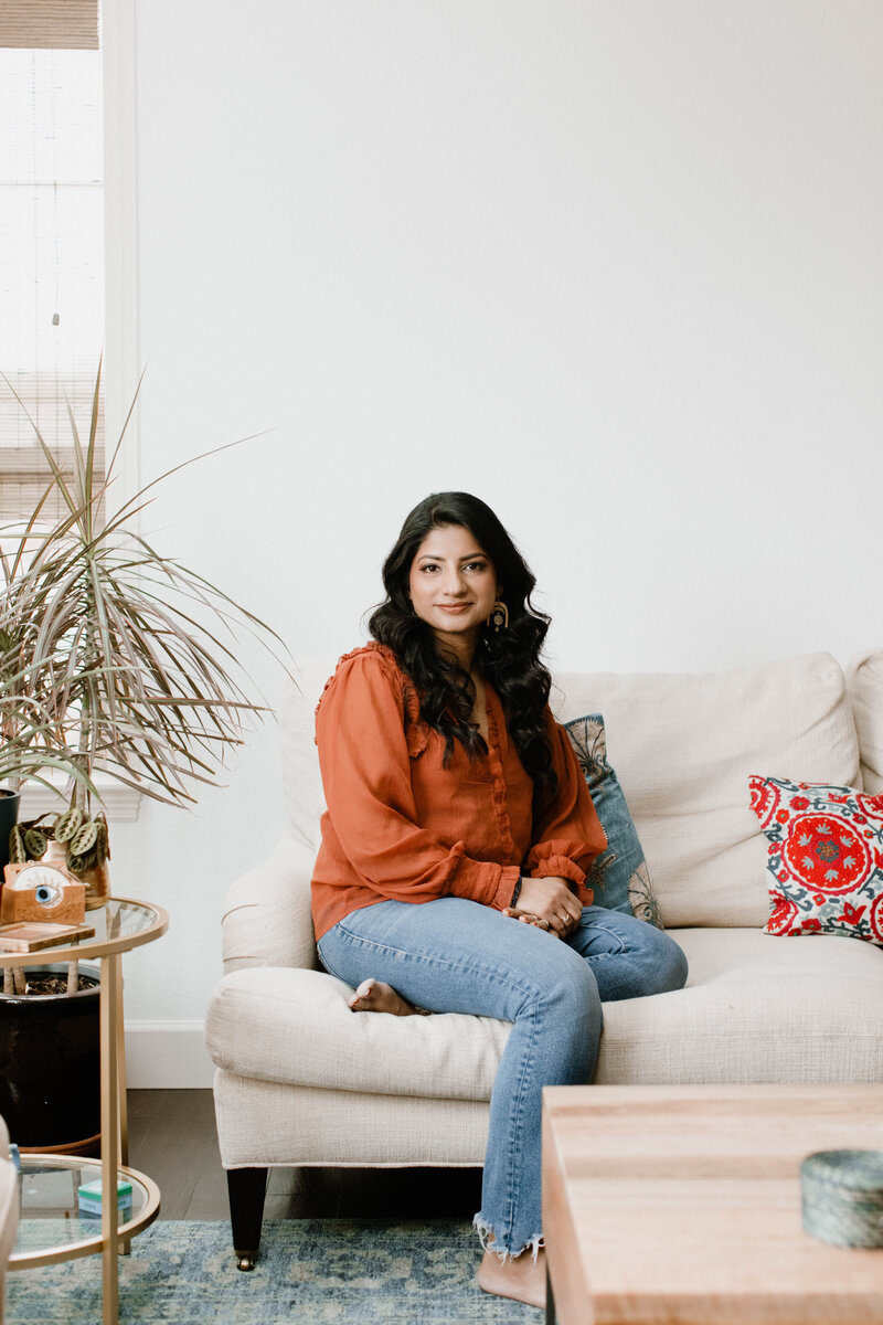 Mindfulness coach Radhika sitting on a white couch