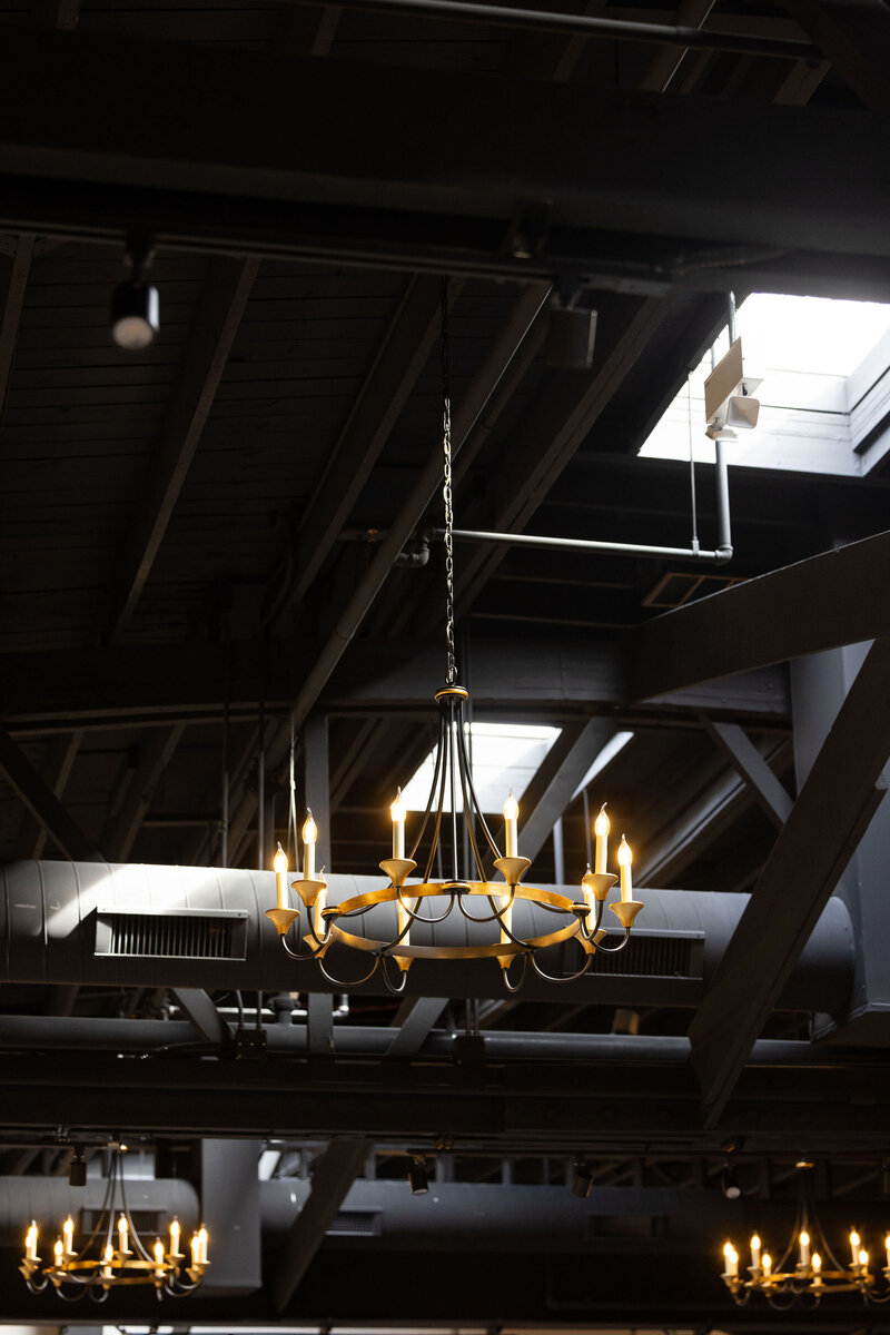 ceremony and reception space natural lighting from skylight mixed with romantic timeless chandeliers