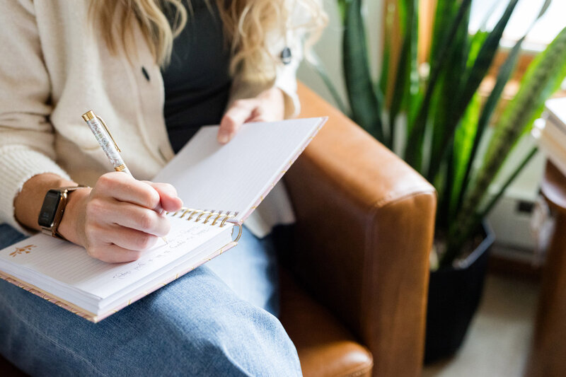 Amy writing in a thick spiral bound notebook