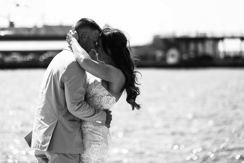 Bride and groom embracing next to the water on Dobbins Landing