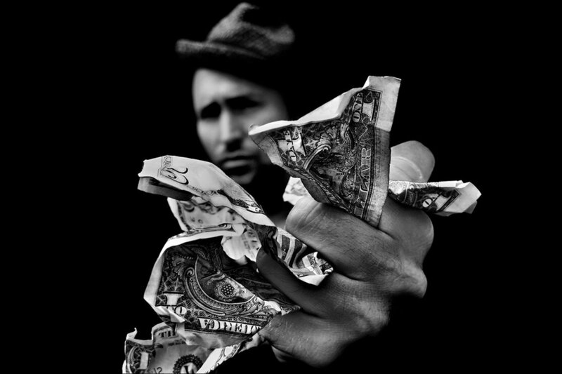 Images From A Glass Eye International Juried Photography Show Portrait The Money Shot black and white man in hat holding a fist full of dollar bills outstretched toward camera