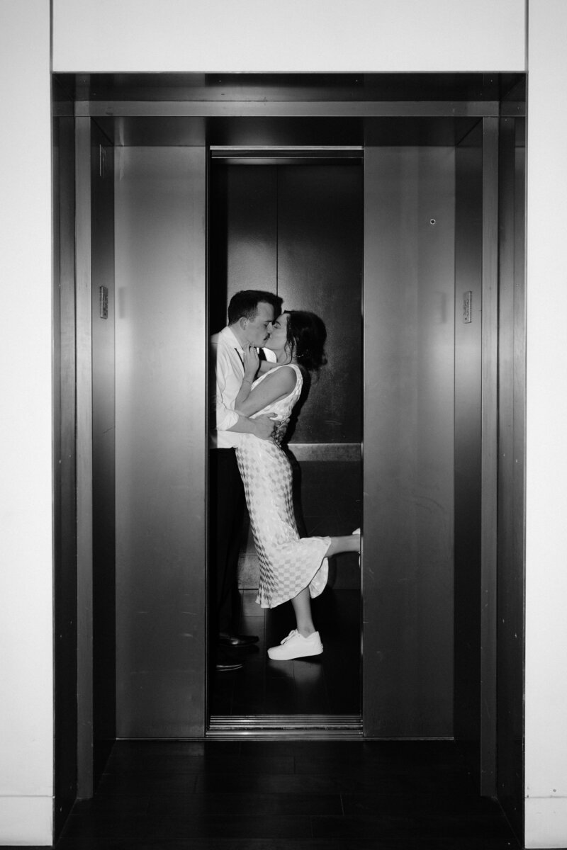 bride and groom kiss in elevator