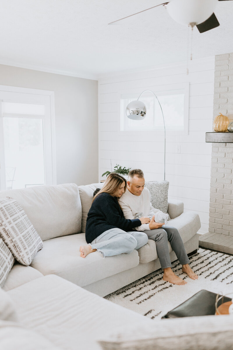 A newborn baby lays on a bed with white sheets for it's lafayette, Indiana newborn photography session. 