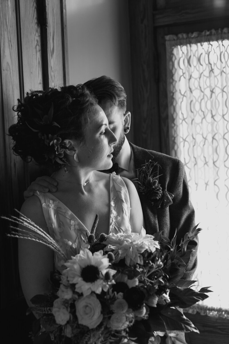 bride and groom next to window