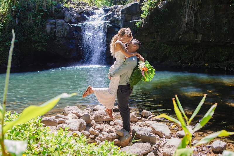 A bride and groom elope in Maui in front of a waterfall