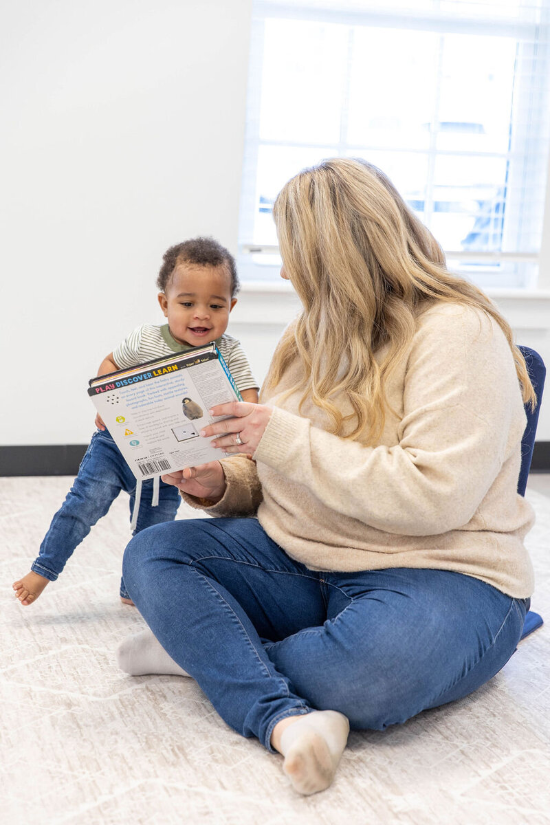 Woman showing a book to a toddler