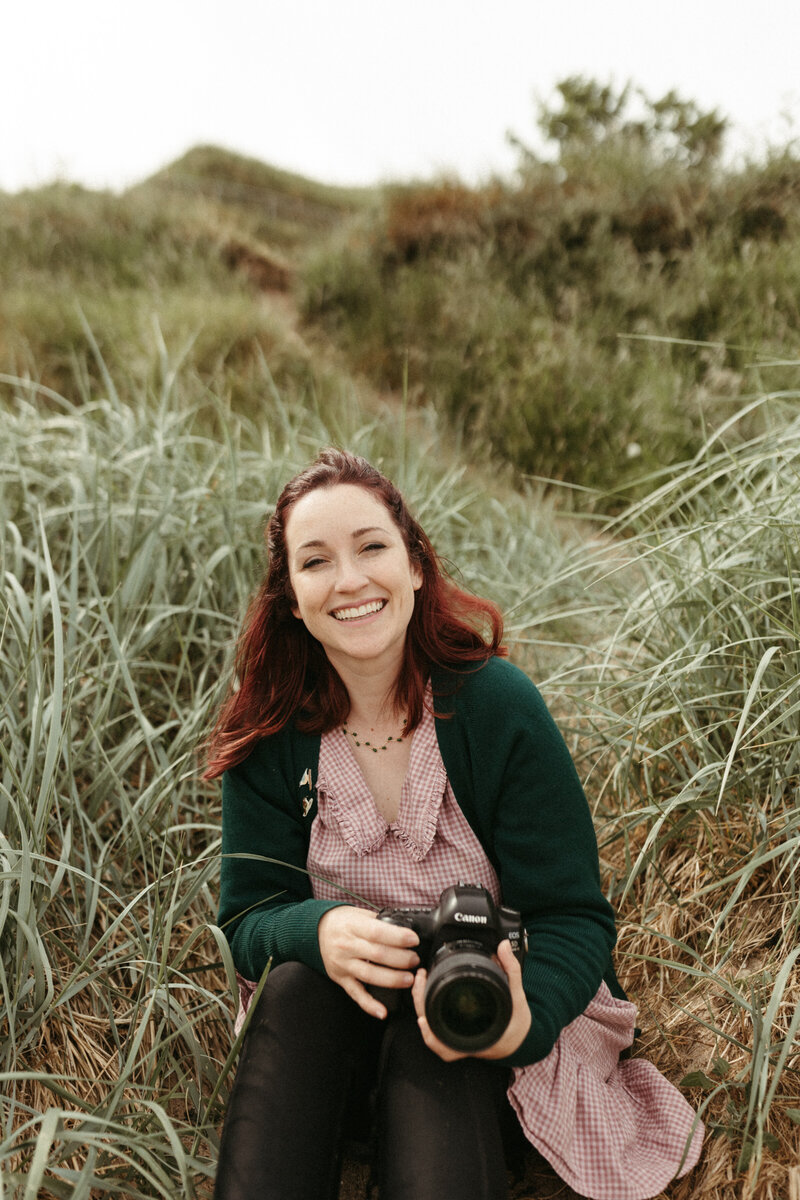 american photographer in scotland holding camera smiling