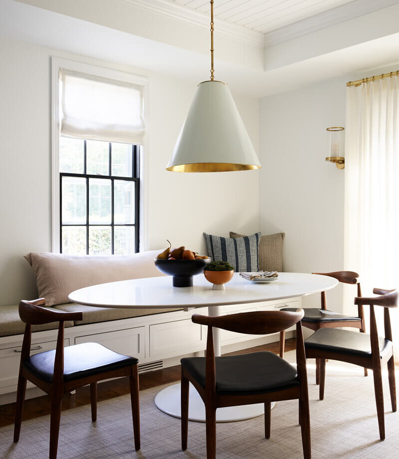 A modern dining table complements historic architecture in a Boston home, part of a renovation and new construction project by a Boston-area interior designer.
