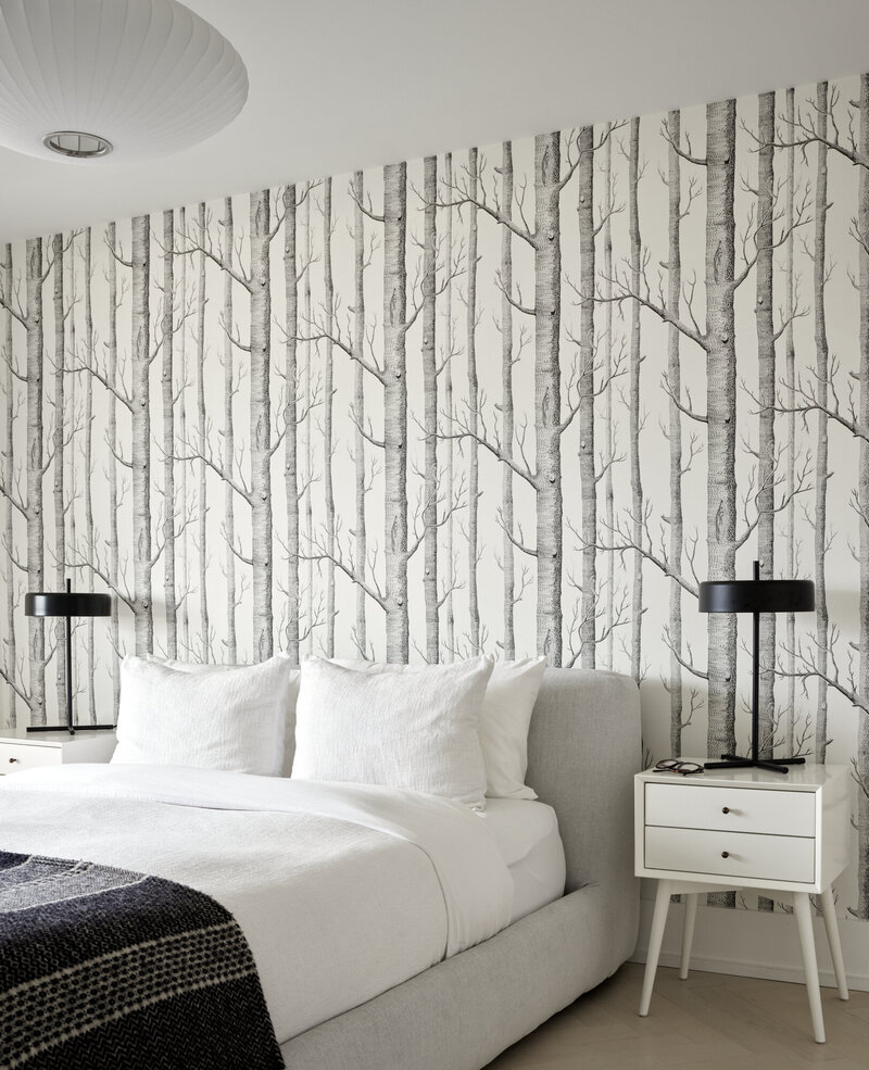 A bright, minimalistic bedroom  containing modern artwork and stylings