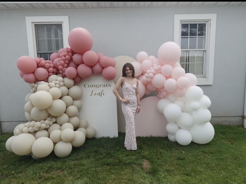 Balloon arch and custom backdrop reading ‘Congrats Leah’ in blush and neutral tones, styled by Yours Truly, a wedding planner and designer in New Jersey.