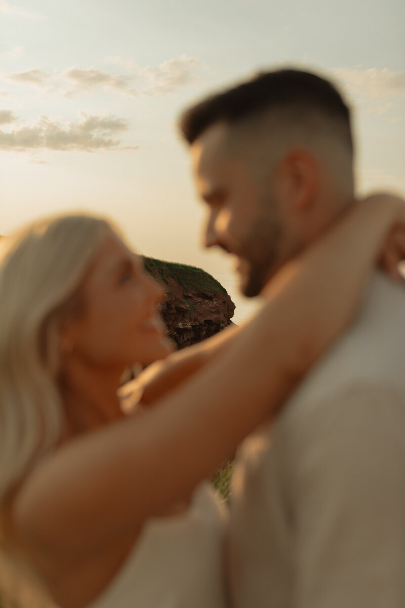 couple embracing on beach for lifestyle photos in pei