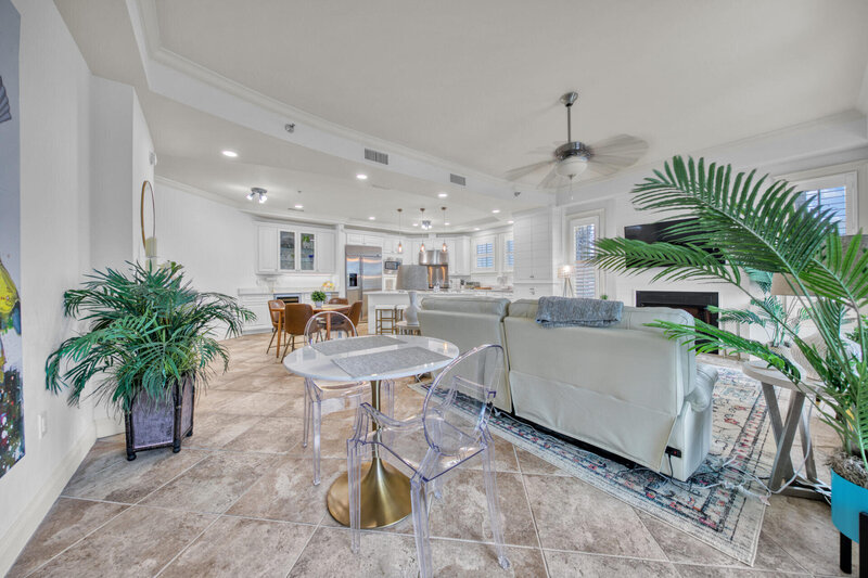 living room with white furniture, round dining table, and clear chairs